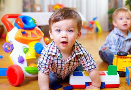 two little boys are playing with plastic toys on the floor