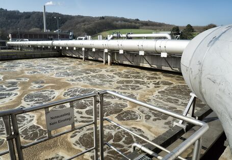 Becken einer Kläranlage mit braunem, schaumigem Wasser
