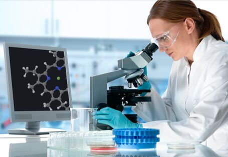 Wissenschaftlerin an einem Mikroskop