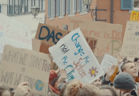 Jugendliche auf einer Demonstration halten Plakate für mehr Klimaschutz in die Luft 