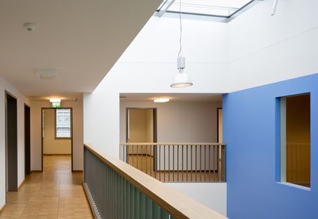 Flure mit Holzfußböden auf einer Galerie, weiße und blaue Wandflächen