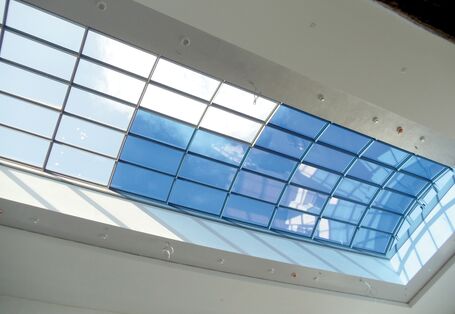 großes Dachflächenfenster aus vielen verschiedenen Glasflächen, einige sind durchsichtig, andere bläulich