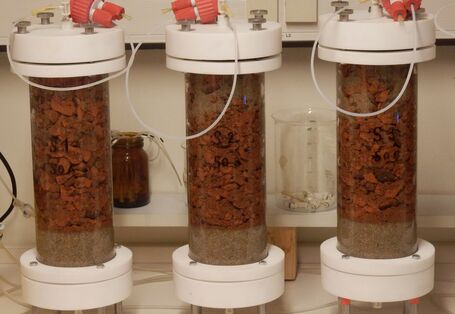 Drei Prüfzylinder gefüllt mit Bauprodukten