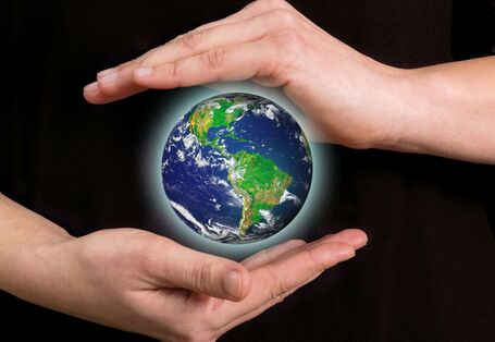 zwei Hände beschützen den Planet Erde