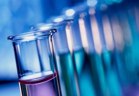 Reagenzgläser mit verschiedenfarbigen Flüssigkeiten in einem Ständer