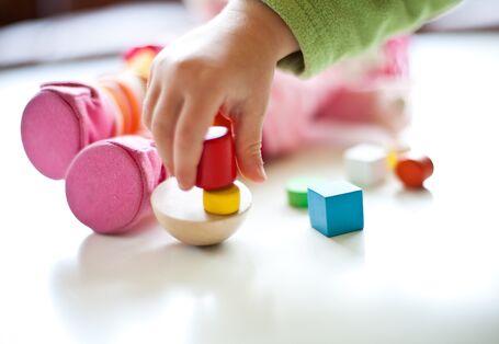 a child´s hand playing with toys