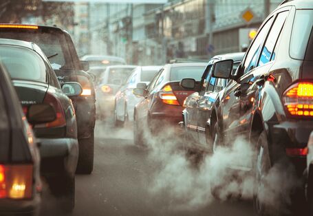 Pkws im städtischen Stau mit sichtbarer Abgasfahne 