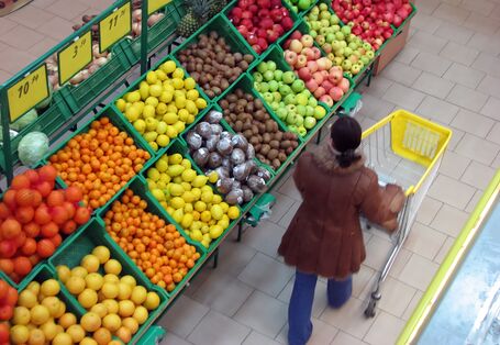 Frau im Supermarkt vor Obstregal