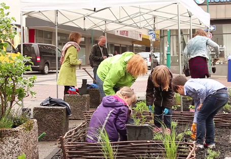 Erwachsene und Kinder bei einer Urban-Gardening-Aktion