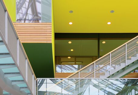 Skywalks and stairs with glass banisters in inner courtyard, inner façade of wood, yellow and green surfaces