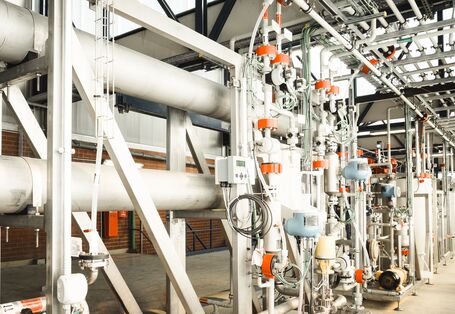 Anlage mit vielen Rohrleitungen in einer Werkshalle