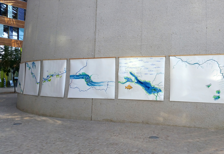 im Vorraum des Umweltbundesamtes Dessau hängen große weiße Bilder nebeneinander, auf denen ein Flusslauf gemalt ist