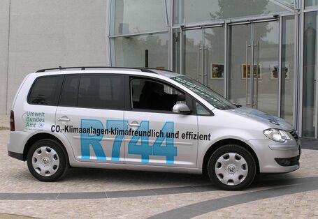 VW-Auto mit der Aufschrift "R744, CO2-Klimaanlagen - klimafreundlich und effizient" und dem Logo des Umweltbundesamtes