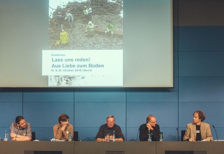 Aufnahme von fünf Teilnehmern der Podumsdiskussion, hinter ihnen eine Leinwand mit dem heutigen Thema