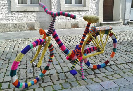 Ein Fahrrad, das komplett mit bunter, gestrickter Wolle umhüllt wurde
