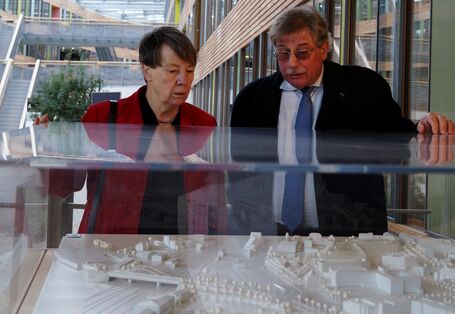 Barbara Hendricks und UBA-Vizepräsident Holzmann stehen an einer Vitrine und betrachten ein Modell des UBA-Gebäudes in Dessau-Roßlau.