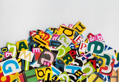 Bunte, aus Zeitschriften ausgeschnittene Buchstaben liegen auf einem Haufen