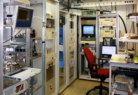 Messraum des Umweltbundesamts in einer Luftmessstation mit mehreren Motioren, Computer, Messgeräten und einem PC-Arbeitsplatz