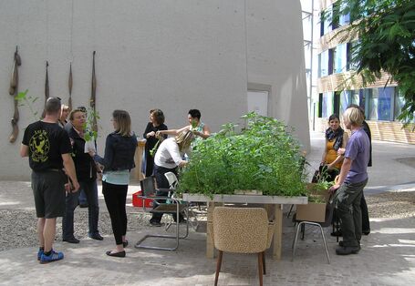 Forum des UBA: Garteninstallation mit hochgewachsenen Pflanzen und Menschen, die diese besichtigen