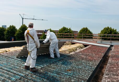 Workers remove asbestos roof sheets