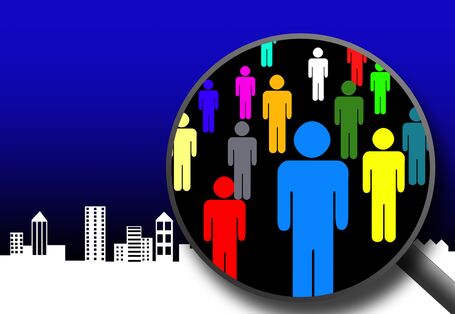 bunte symbolisierte Menschen in der Lupe