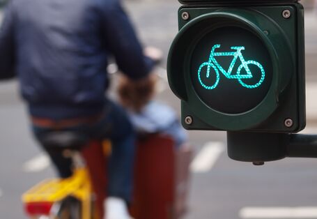Fahrradampel steht auf Grün, Mann mit gelbem Rad ist vorbeigefahren