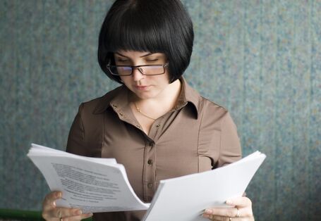 Frau schaut auf beschriebenes Papier