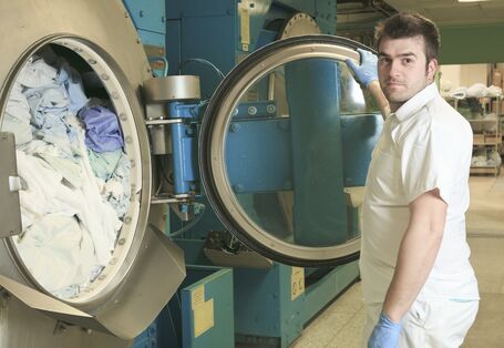 Mann vor Industriewaschmaschine