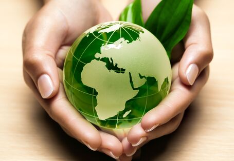 Zwei Hände halten die grüne Erdkugel