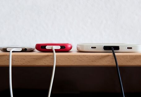 Drei Smartphones am Ladekabel