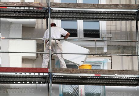 Bauarbeiter dämmen ein Haus