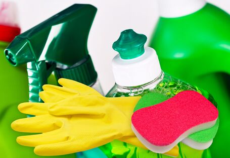 Reinigungsmittelflaschen, Gummihandschuhe, Putzschwamm