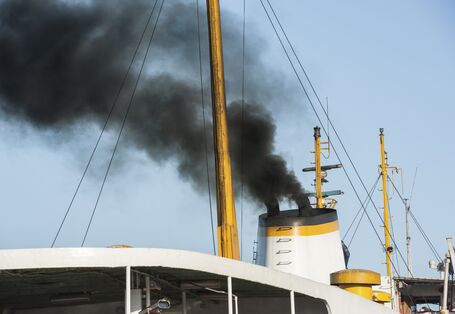 aus dem Schiffsschornstein quillt schwarzer Rauch 