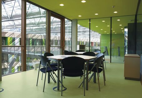 Besprechungsraum mit Tisch und Stühlen, ausgelegt mit elastischem Fußbodenbelag