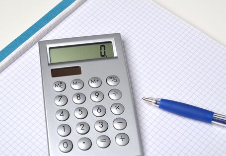 solarbetriebener Taschenrechner und ein Kugelschreiber auf einem Schreibblock