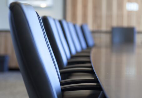 gepolsterte Stühle an einem Tisch in einem Sitzungsraum