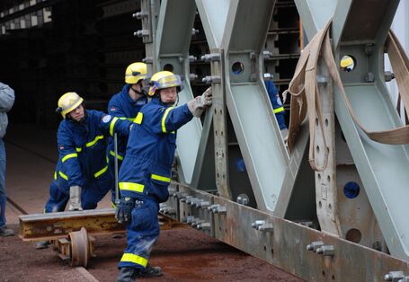 Einsatzkräfte des THW schieben eine große Stahlkonstuktion.