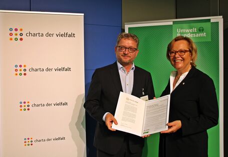 Zwei Personen mit der unterzeichneten Charta der Vielfalt