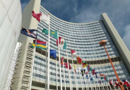 Fahnenmasten mit Fahnen vor einem Hochhaus