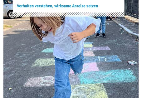 Ein Kind springt auf einer mit Kreide bemalten Straße herum