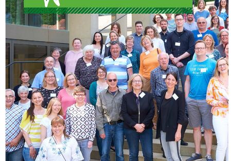 Menschen stehen auf einer Treppe und schauen in die Kamera