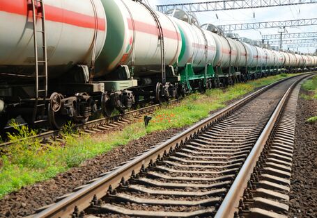 Langer Güterzug auf einem Gleis. Daneben eine leere Schiene.