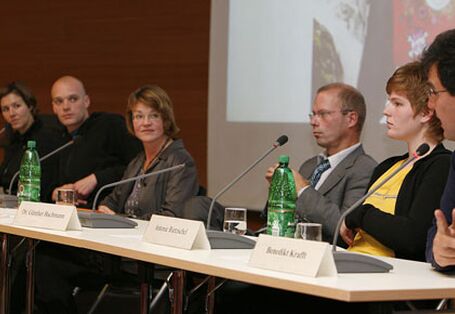 Die Diskutanten blicken auf den Schulleiter am rechten Rand der Tafel, der gerade in sein Mikrophon spricht