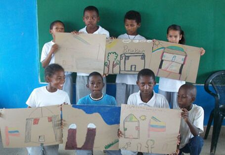 Kinder halten ihre Zeichnungen in die Kamera und strahlen