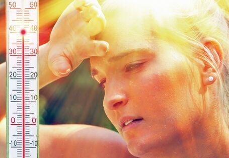 The picture shows a woman’s face with beads of perspiration caused by the summer heat. The woman is holding a hand to her forehead. In the left-hand side of the picture is a thermometer indicating 40°C air temperature.