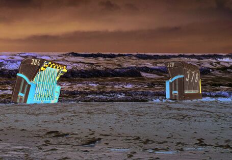 Das Bild zeigt einen Sandstrand an der Ostsee. Ein Strandkorb am Strand wird teilweise vom Wasser umspült. Im Hintergrund sind das Meer mit starkem Wellengang und dunkle Gewitterwolken zu sehen.