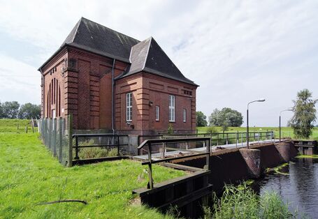 The picture shows the pumping station Steinschleuse on the Eider river. A retaining wall with a bridge and a brick-built house are visible.
