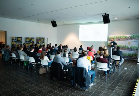 Bild vom Veranstaltungsraum mit Teilnehmenden