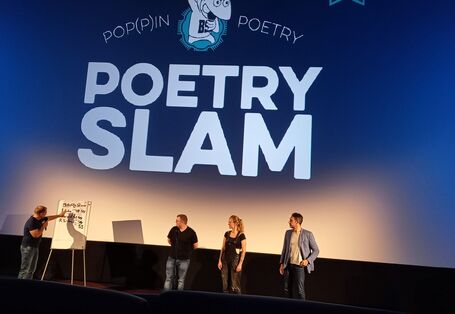 Menschen auf der Bühe beim Poetry Slam