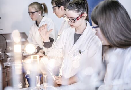 Ein Foto im Labor mit mehreren Mädchen, die sich für den Mädchen-Zukunftstag angemeldet haben, um einen Einblick in die Berufswelt zu erhalten. 